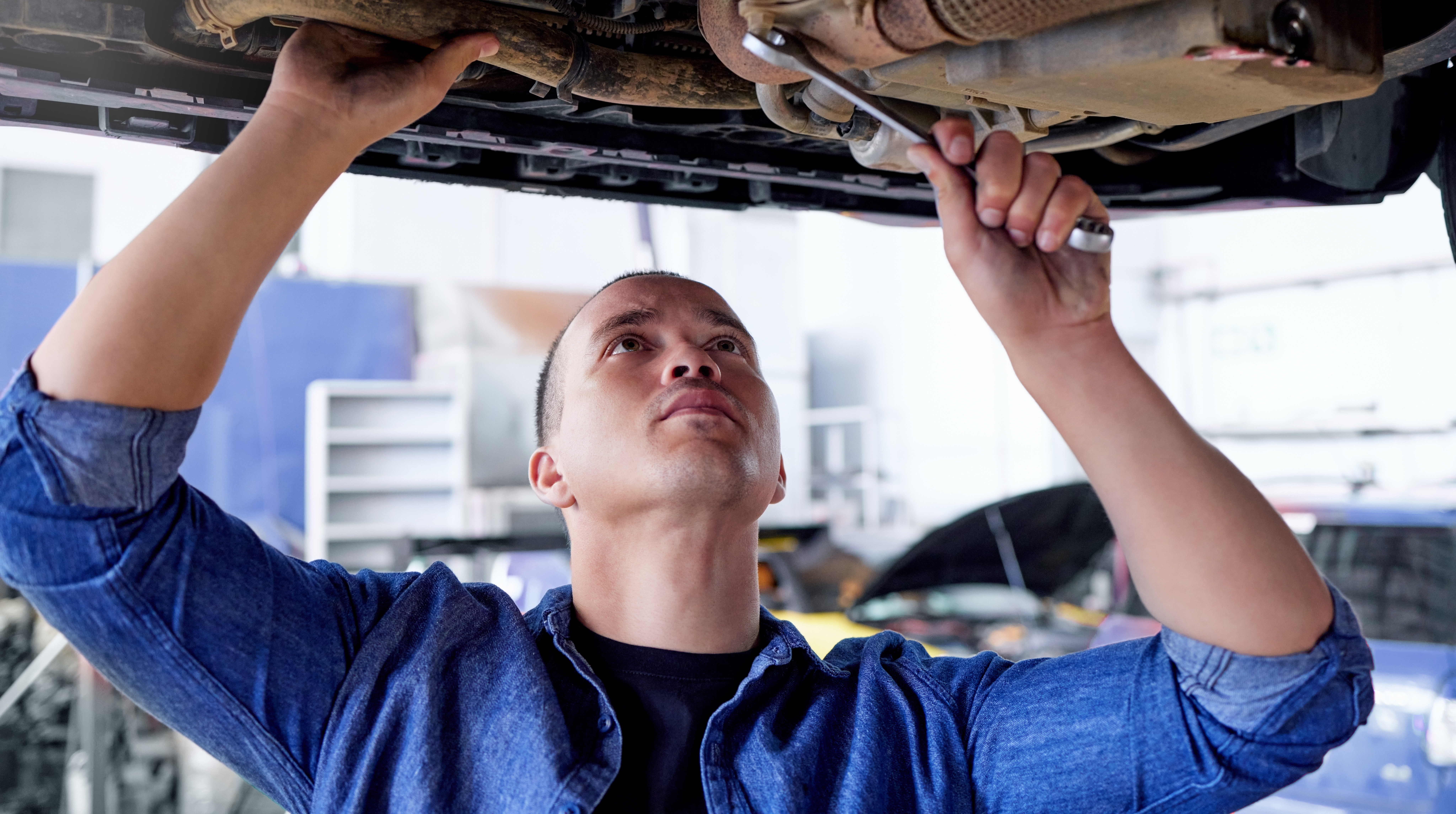 Mechanic, engineer and car with a man at work in a garage or service center for the transport indus